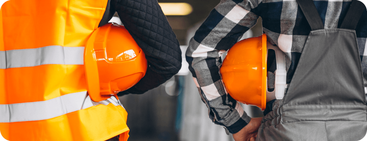 Two crew members with orange hard hats on a waterproofing job site