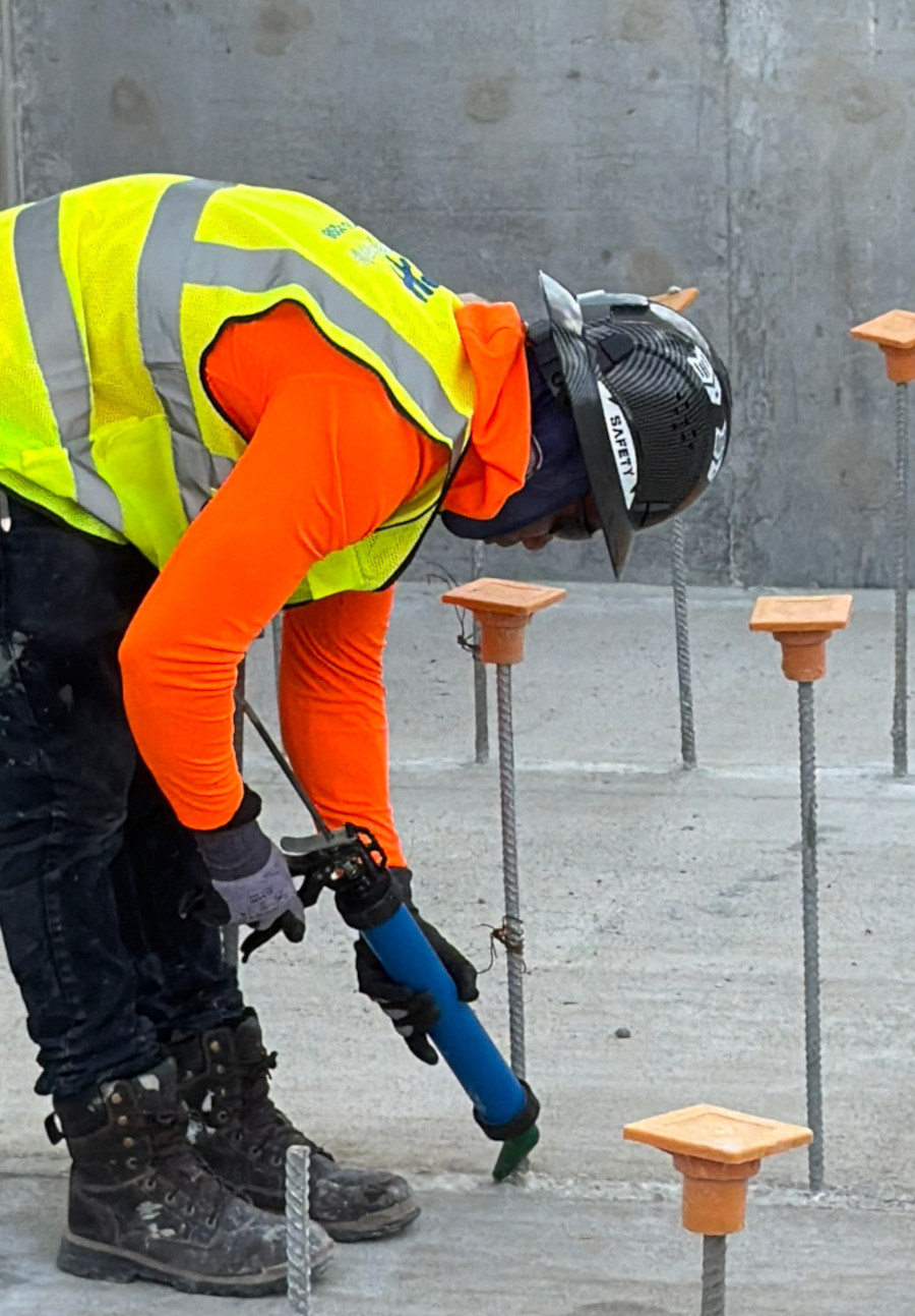 Waterproofing technician applying sealant with a caulking gun