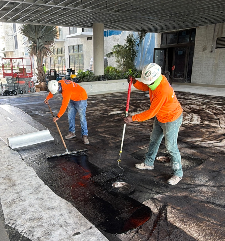 Crew applying waterproofing membrane on a deck