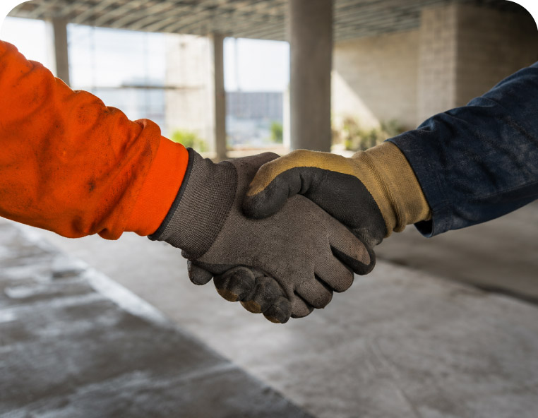 Tech Waterproofing crew member in a yellow hard hat and orange shirt applying coating on a high-rise balcony